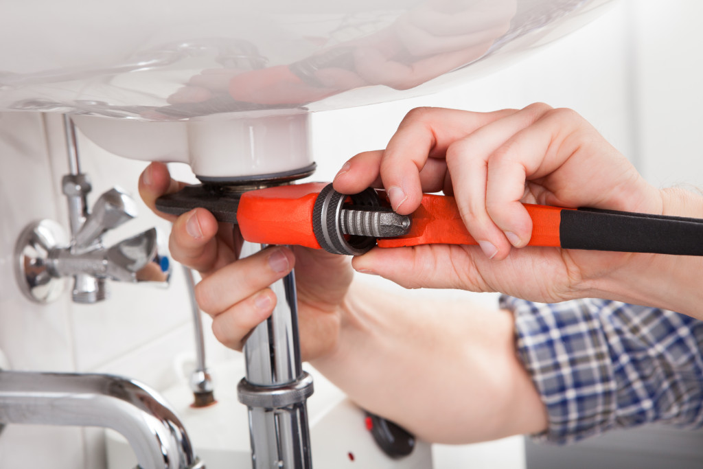male plumber fixing sink in bathroom